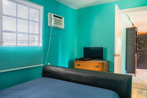 a bedroom with green walls and a bed and a television at GpL 2668 one bedroom in Fort Myers