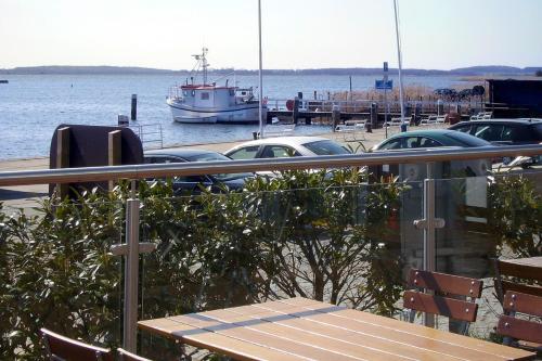 a boat is docked at a marina with cars at Pension Mola in Breege