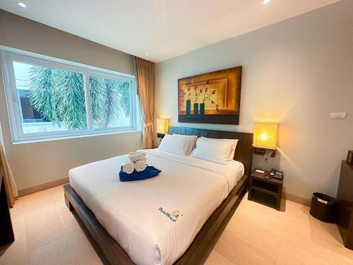 a bedroom with a large white bed with a window at NEW Malee Resort Studio 858 in Rawai Beach