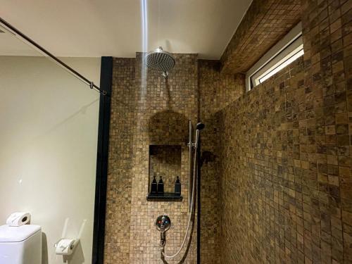 a shower in a bathroom with a tile wall at NEW Malee Resort Studio 858 in Rawai Beach