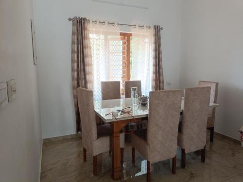 a dining room with a table and chairs at La- casona in Kottayam