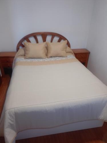 a white bed with two pillows on top of it at Corme camiño dos faros, playa Galicia in Corme-Puerto