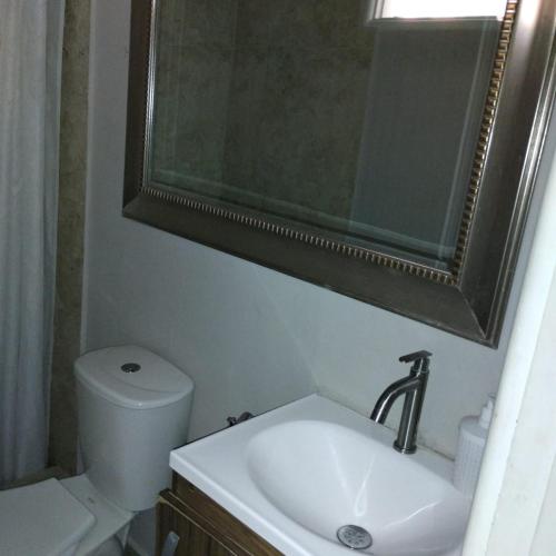 a bathroom with a sink and a toilet and a mirror at Capitel Hostel in Cartagena de Indias