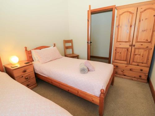 a bedroom with two twin beds and a dresser at The Old Stables in Blandford Forum