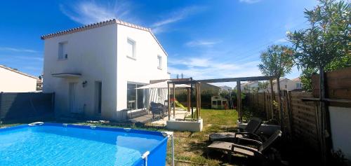 une arrière-cour avec une piscine et une maison blanche dans l'établissement Villa climatisée à Uzès, piscine et centre à pied, à Uzès
