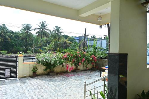 a patio with flowers on a wall and a fence at Anugraha Bed&Breakfast Homestay in Kumta