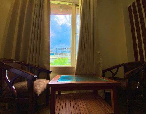 a room with a table and two chairs and a window at Hotel Mantavya in Kakarmatha