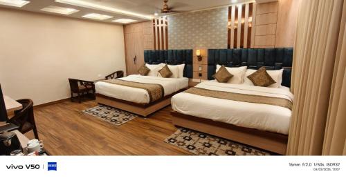 a hotel room with two beds in a room at Hotel Mantavya in Kakarmatha