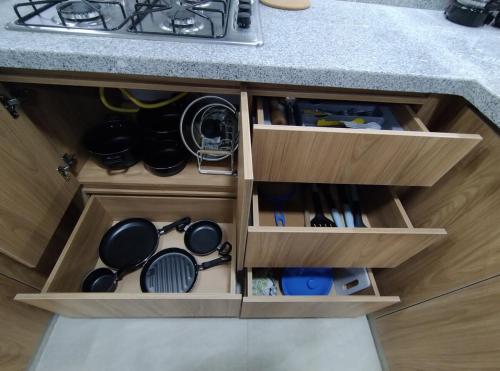 a kitchen with wooden drawers filled with pots and pans at Moderno apto cómodo bien ubicado in Floridablanca