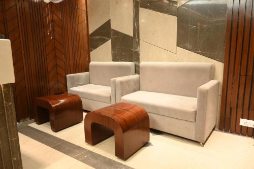 two chairs and a stool in a room at Hotel Mantavya in Kakarmatha