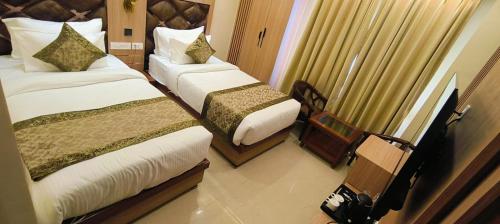 a hotel room with two beds and a window at Hotel Mantavya in Kakarmatha