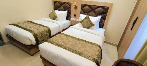 a hotel room with two beds in a room at Hotel Mantavya in Kakarmatha