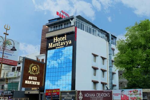 a building with a sign on the side of it at Hotel Mantavya in Kakarmatha