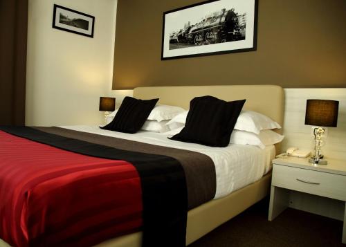 a hotel room with a large bed with a red blanket at Stelle Hotel The Businest in Naples