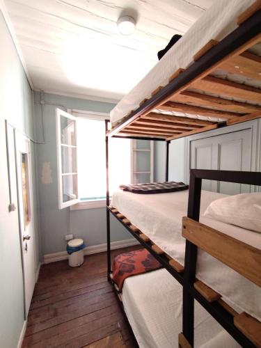 two bunk beds in a room with a window at Hostal Perro Watón in Valparaíso