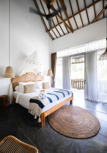 a bedroom with a large bed and a large window at Amar Boutique Hotel in Canggu