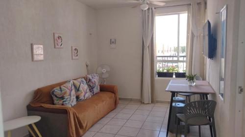 a living room with a couch and a table and a window at Breezy & Cancunian Villa in Cancún