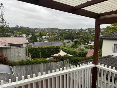 a white fence with a view of a city at Hillcrest Homestay in Auckland