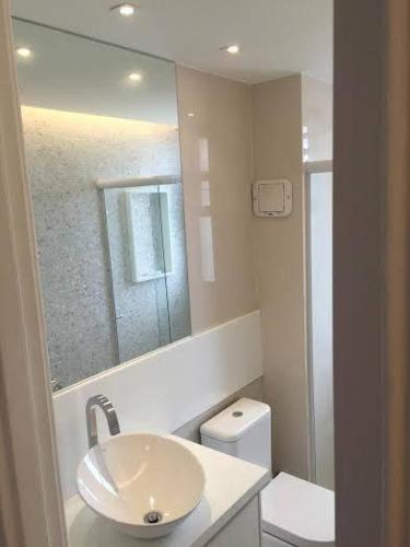 a white bathroom with a sink and a mirror at Malawi Resort Essence in Porto De Galinhas