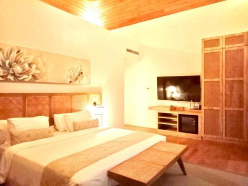 a bedroom with a large bed and a flat screen tv at Truntum Boutique Mandalika in Kuta Lombok