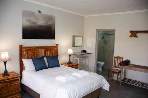 a bedroom with a bed with blue pillows at Tooiselvere in George