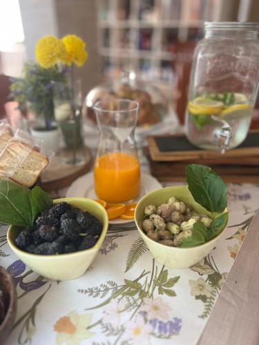 a table with two bowls of food and orange juice at La Casa del Vagabondo in Belvedere