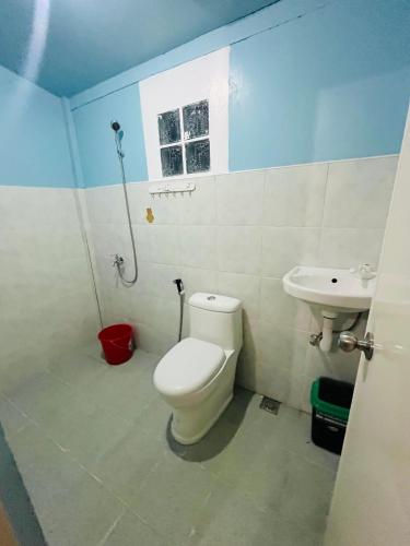 a bathroom with a toilet and a sink at Lugadia Inn- Abels El nido in El Nido
