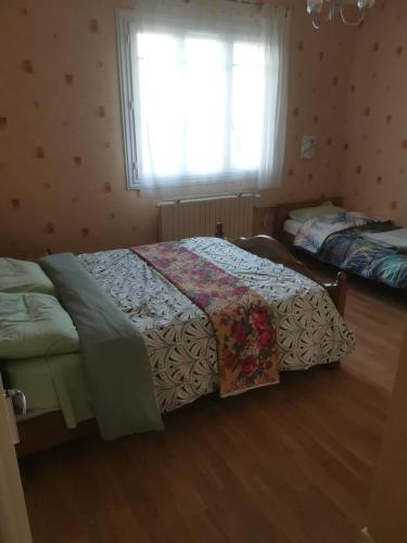 une chambre avec deux lits et une fenêtre dans l'établissement le pavillon a la campagne, à La Perche