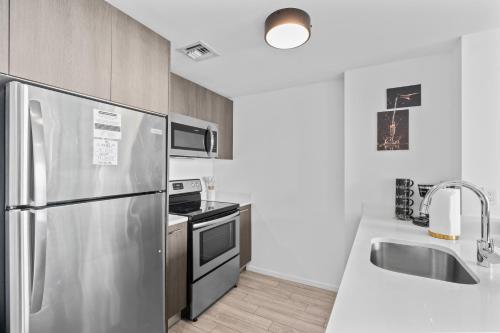 a kitchen with a stainless steel refrigerator and a sink at Luxury Suite Heated pool & jacuzzi in Miami