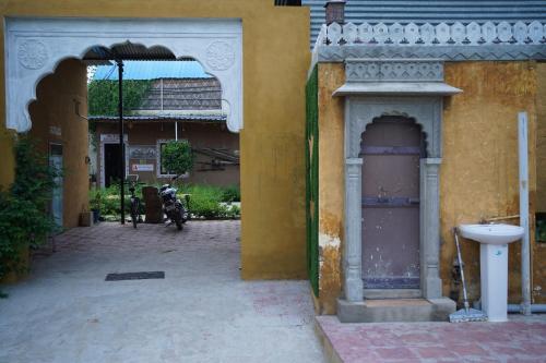 a yellow building with a sink in a courtyard at jor ki dhani in Dadhia