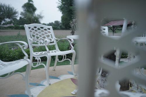 a couple of white chairs sitting on a patio at jor ki dhani in Dadhia