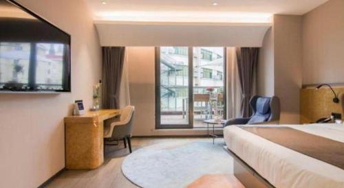 a hotel room with a bed and a desk and a window at Yitel Collection Shanghai Hongqiao Airport in Shanghai