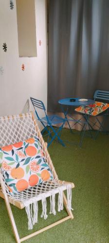 a room with a bed and two chairs and a table at Le petit soleil, 5 mn de la plage et de l'embarcadère, parking et wifi gratuits in Toulon