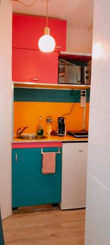 - une cuisine colorée avec un évier et une cuisinière dans l'établissement Le petit soleil, à Toulon