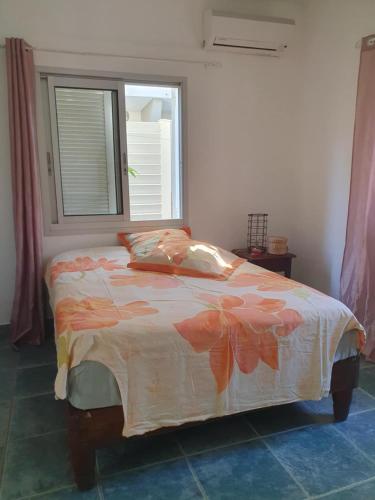 a bedroom with a bed with a window at Garden & Terrace Apartment in Noumea