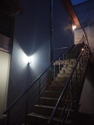 a staircase in a building with a light at night at Eleni Kandilari Rooms in Kókkinon Nerón