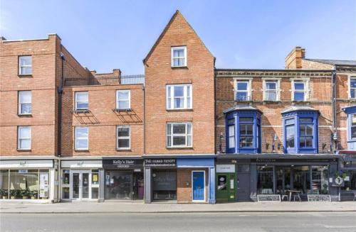 a large brick building with blue windows on a street at The Oxford Veranda in Oxford
