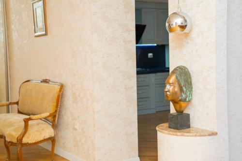 a statue of a head sitting next to a chair at Sunday Hotel & Apartments in Baku