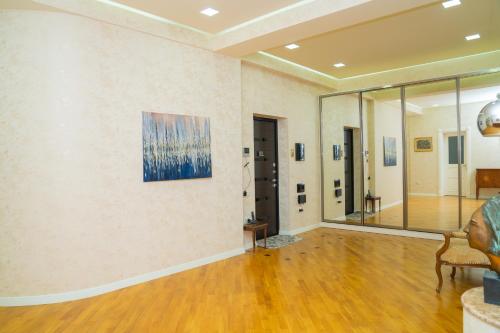 a living room with a couch and a painting on the wall at Sunday Hotel & Apartments in Baku