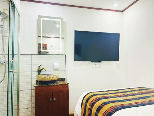 a bedroom with a bed and a tv on the wall at Nost algia Hotel Beijing Tiananmen Square & Qianmen Subway St ation 时光漫步酒店 北京天安门广场前门地铁站店 Free laundry service in Beijing