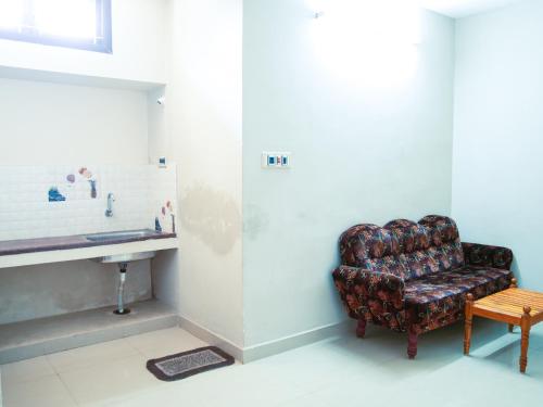 a living room with a chair and a sink at Thirumalai Home Stay - Group & Family Stay Room VL Swami Malai Temple in Kumbakonam