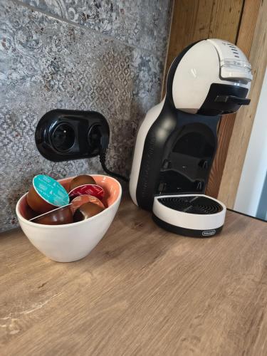 a coffee maker sitting on a counter with a bowl of chocolate at Apartamenty Stara Cegła in Zgorzelec