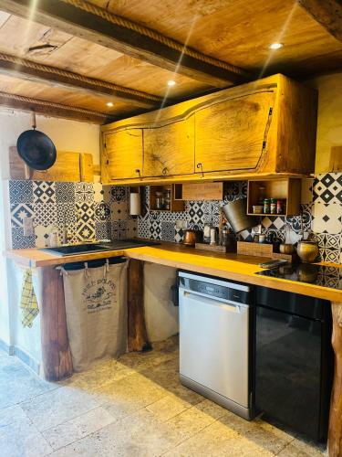 - une cuisine avec des placards en bois et un lave-vaisselle dans l'établissement Charming house with sea view Emily in Porri, à Porri