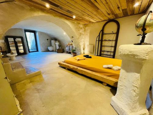 - une chambre en pierre avec un grand lit dans l'établissement Charming house with sea view Emily in Porri, à Porri