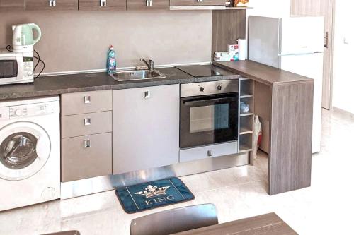 a kitchen with a sink and a washing machine at Family Apartment Near Beach, Pools & Star dreams Complex in Sveti Vlas