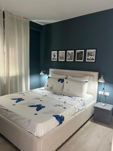 Ein Schlafzimmer mit einem großen weißen Bett und blauen Wänden in der Unterkunft Sunset Resort in Vlorë