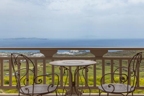 a table and chairs on a balcony with a view of the ocean at Soborgo Exquisite Villas in Tinos Town