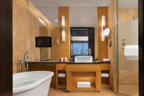 a bathroom with a bath tub and a sink at Changsha Huatian Hotel in Changsha