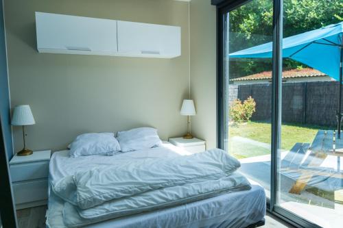 une chambre avec un lit et une grande fenêtre dans l'établissement La Tiny L Loches, proche Zoo de Beauval, à Loches