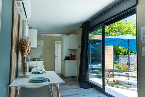 a kitchen and living room with a white table and chairs at La Tiny L Loches, proche Zoo de Beauval in Loches